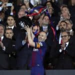 FC Barcelona's midfielder Andres Iniesta raises the Copa Del Rey trophy