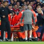 Arsenal manager Arsene Wenger speaks with Arsenal's Laurent Koscielny as he is stretchered off.