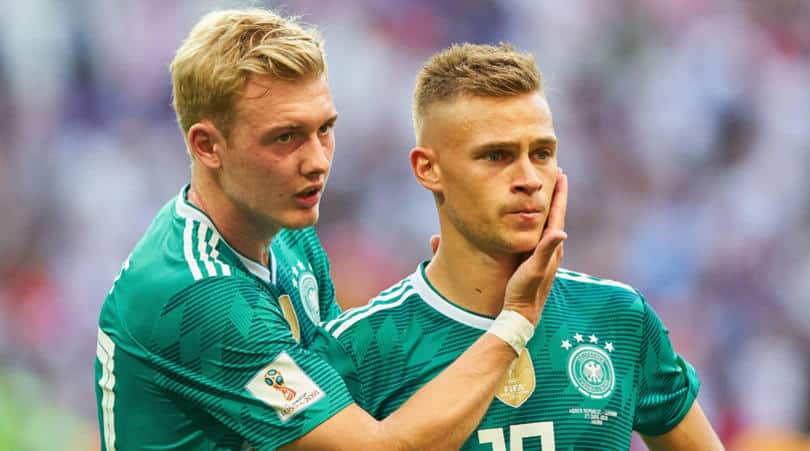 Joshua Kimmich consoled bu Julian Brandt after Germany's World Cup elimination.