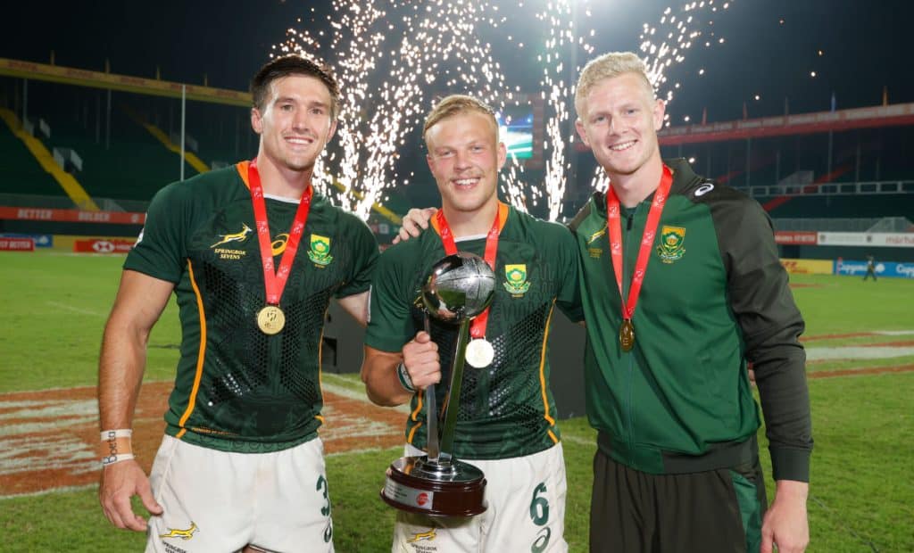 South Africa's Impi Visser, JC Pretorius, and Ryan Oosthuizen celebrate with the Cup trophy on day two of the Dubai Emirates Airline Rugby Sevens 2021 men's competition on 27 November, 2021. Photo credit: Mike Lee - KLC fotos for World Rugby/BackpagePix