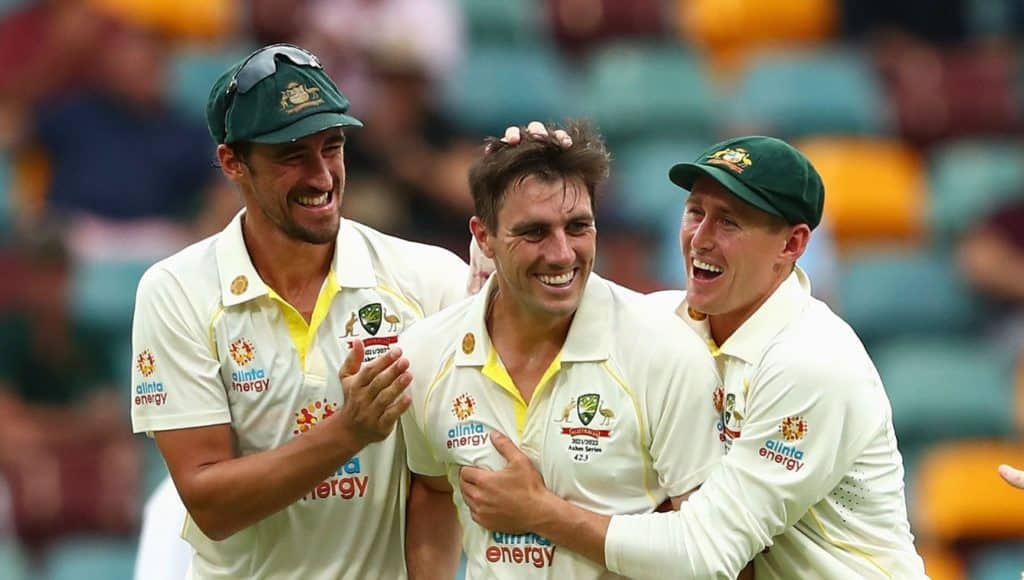 BRISBANE, AUSTRALIA - DECEMBER 08: Australian captain Pat Cummins celebrates with team mates after dismissing Chris Woakes of England during day one of the First Test Match in the Ashes series between Australia and England at The Gabba on December 08, 2021 in Brisbane, Australia. (Photo by Chris Hyde/Getty Images)