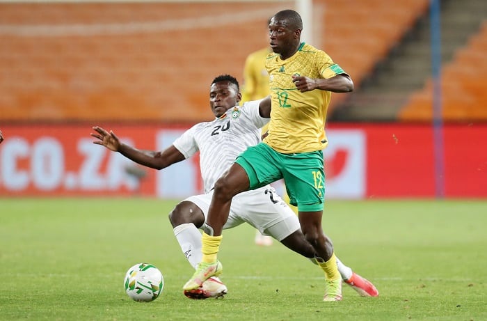 Bongokuhle Hlongwane of South Africa tackled by Farai Madhanaga of Zimbabwe during the 2022 World Cup Qualifier match between South Africa and Zimbabwe