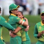 CHRISTCHURCH, NEW ZEALAND - MARCH 31: Marizanne Kapp, left, and Shabnim Ismail from South Africa hug as team mates Ayabonga Khaka, left, and Masabata Klaas right, arrive to celebrate after Kapp caught Natalie Sciver from England off the bowling of Ismail during the 2022 ICC Women's Cricket World Cup Semi Final match between South Africa and England at Hagley Oval on March 31, 2022 in Christchurch, New Zealand. (Photo by Peter Meecham/Getty Images)