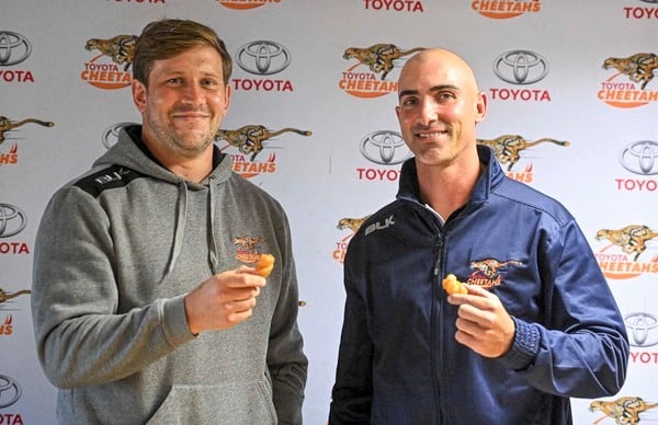 BLOEMFONTEIN, SOUTH AFRICA - MAY 24 Francois Steyn and Ruan Pienaar celebrate with koeksisters after signing to play rugby for another season at the Free State Stadium on May 24, 2022 in Bloemfontein, South Africa. It is reported that the Free State Cheetahs announced the extension of Francois Steyn and Ruan Pienaar for a year. (Photo by Gallo Images/Volksblad/Mlungisi Louw)