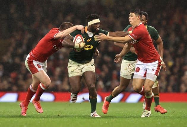 CARDIFF, WALES - NOVEMBER 06: Siya Kolisi of South Africa is tackled by Louis Rees-Zammit and Damian de Allende of Wales during the Autumn Nations Series match between Wales and South Africa at Principality Stadium on November 06, 2021 in Cardiff, Wales. (Photo by David Rogers/Getty Images)