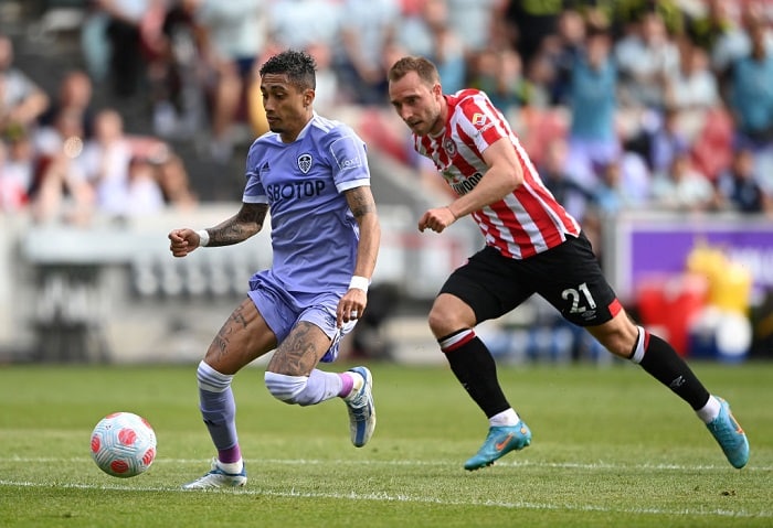 BRENTFORD, ENGLAND - MAY 22: Raphinha of Leeds United breaks away from Christian Eriksen of Brentford during the Premier League match between Brentford and Leeds United at Brentford Community Stadium on May 22, 2022 in Brentford, England. (Photo by Alex Davidson/Getty Images)